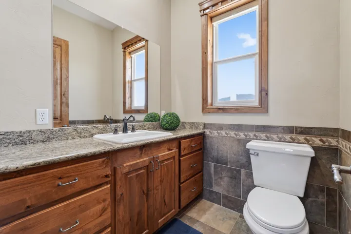 Bathroom with vanity, wainscoting, and tile walls