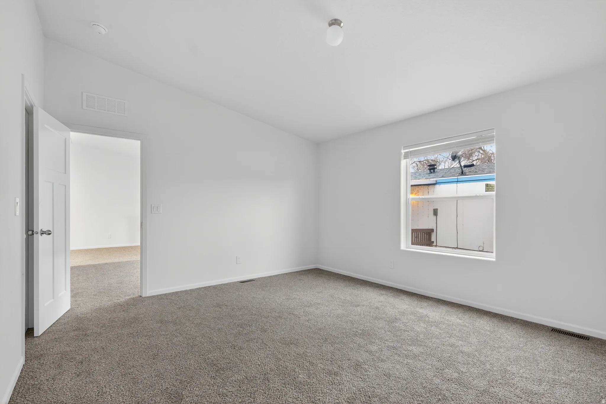 Empty room with lofted ceiling and carpet floors