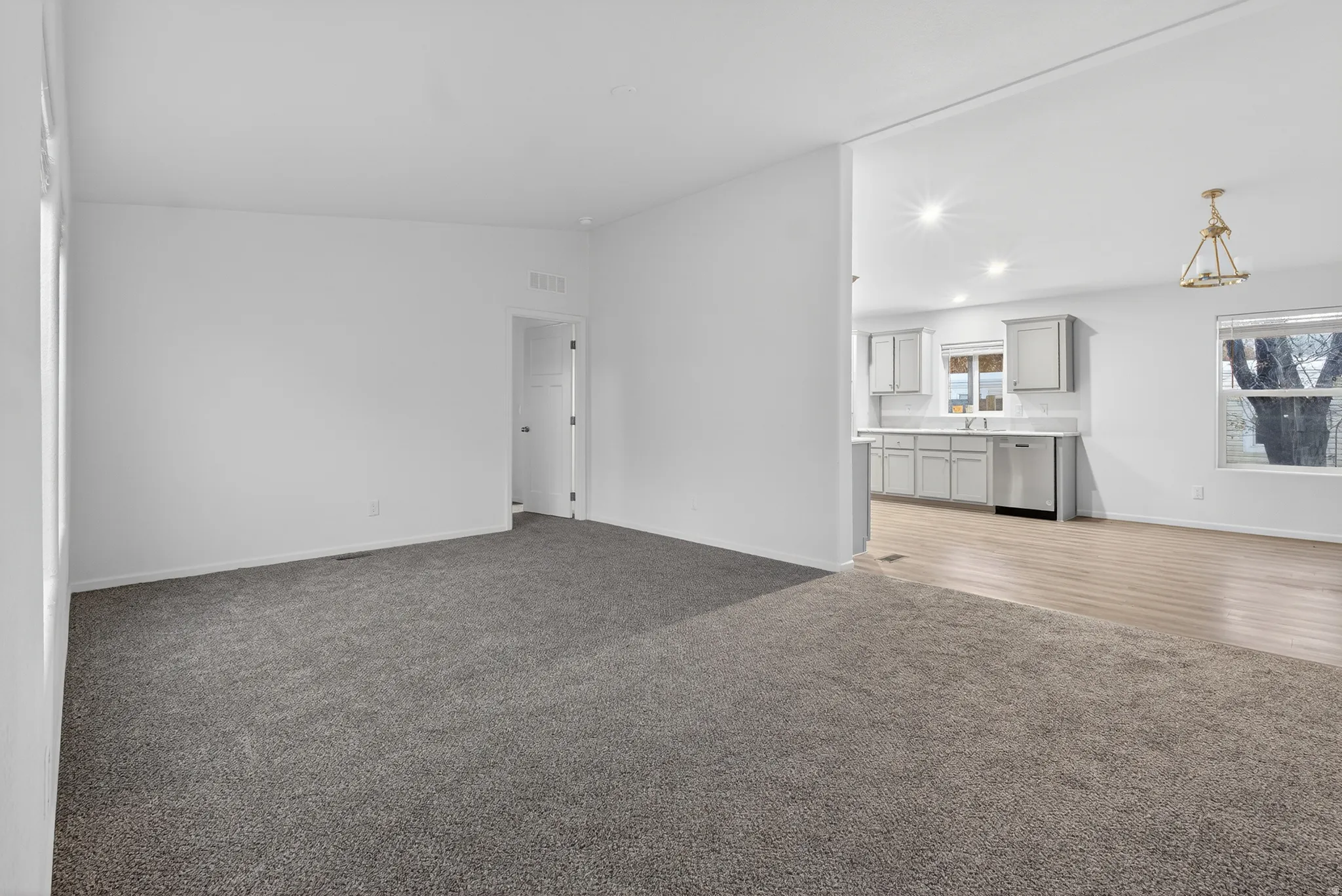 Unfurnished living room featuring dark carpet, lofted ceiling, and recessed lighting