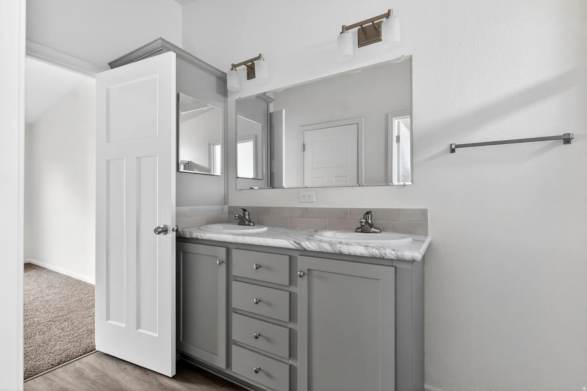 Bathroom with double vanity and light wood-type flooring