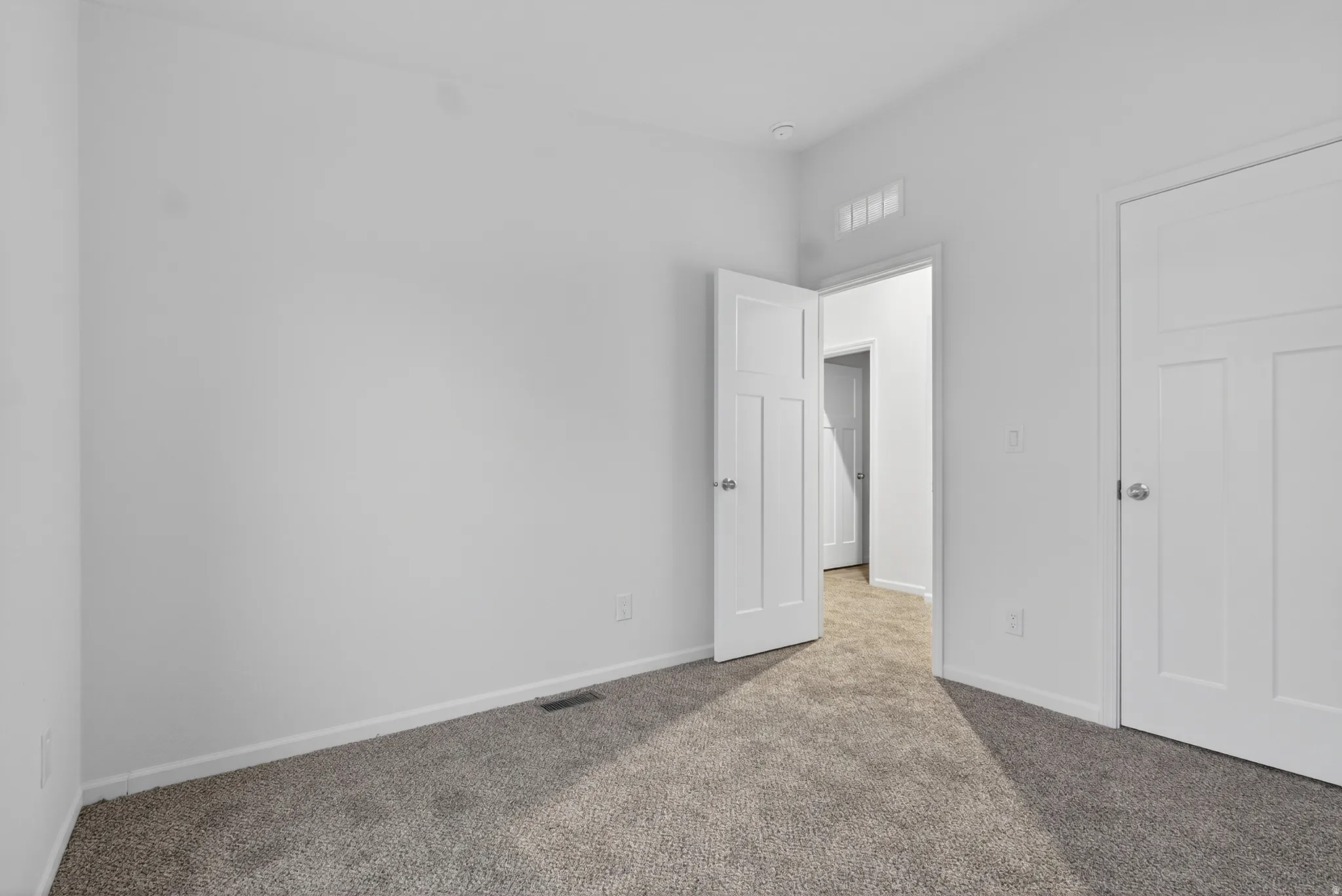 Unfurnished bedroom with carpet floors and baseboards