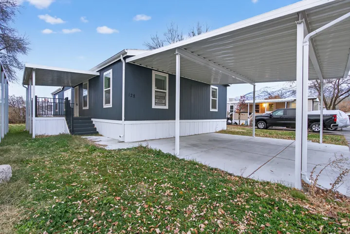View of home's exterior with an attached carport, a lawn, and a porch