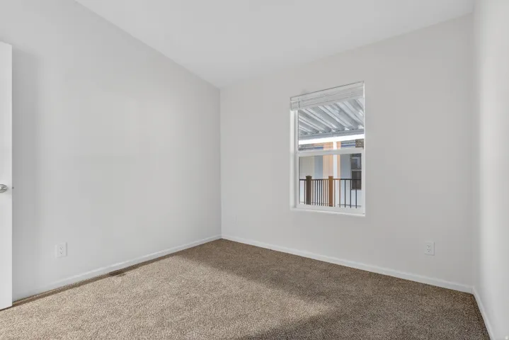Empty room with carpet and baseboards