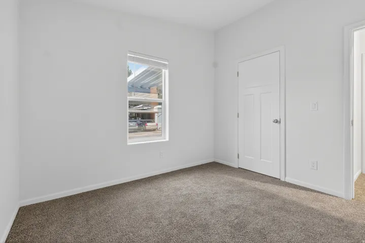 Carpeted spare room featuring baseboards