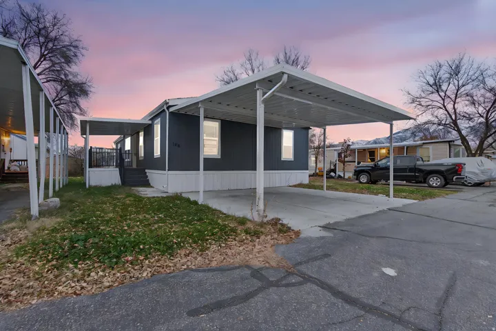 View of property exterior with an attached carport and concrete driveway