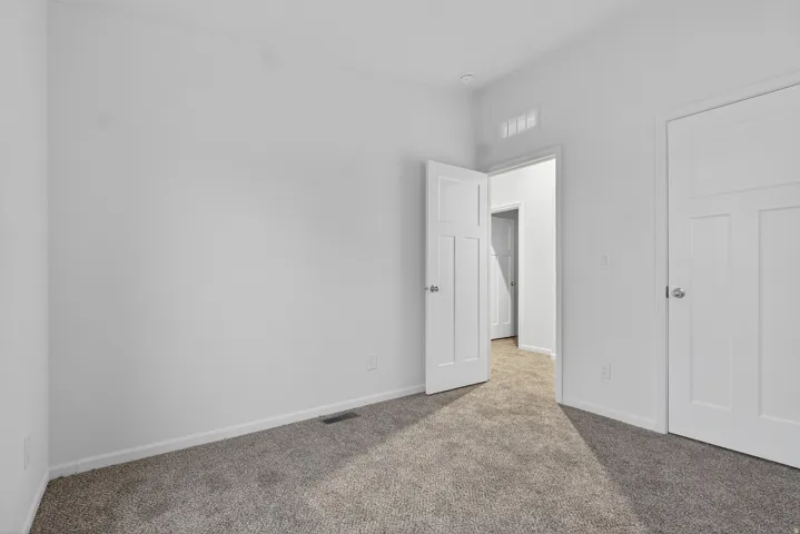Unfurnished bedroom with carpet floors and baseboards