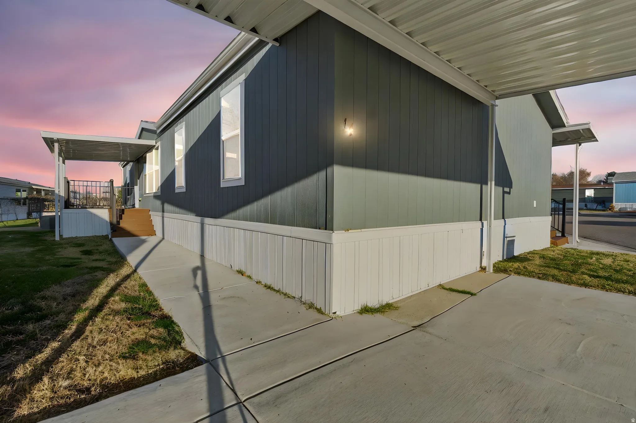 Property exterior at dusk featuring a porch and a yard