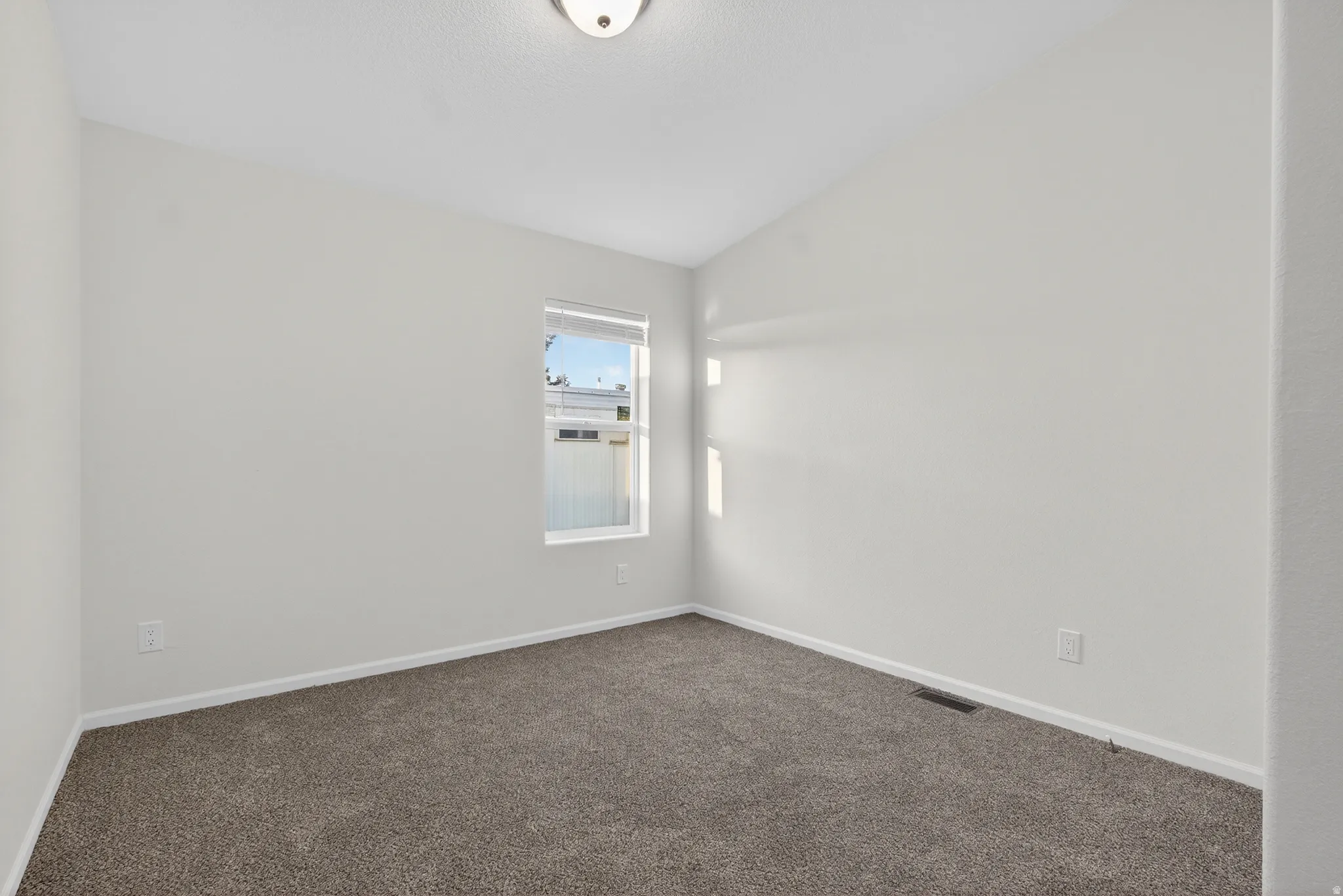 Spare room featuring carpet floors and baseboards