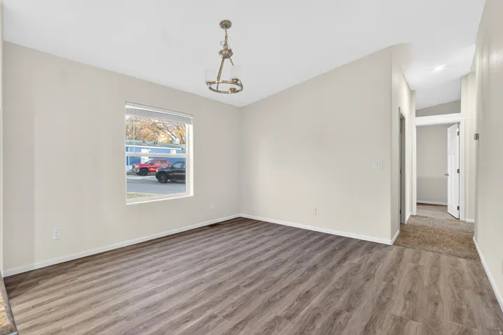 Unfurnished dining area featuring wood finished floors and a chandelier