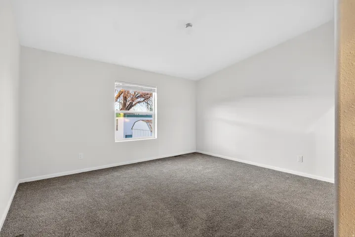 Carpeted spare room featuring baseboards