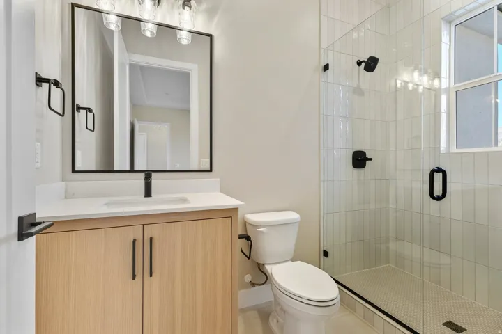 Full bathroom with vanity and a shower stall