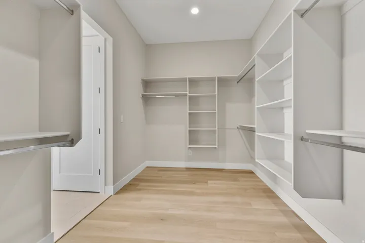 Walk in closet with light wood-style floors