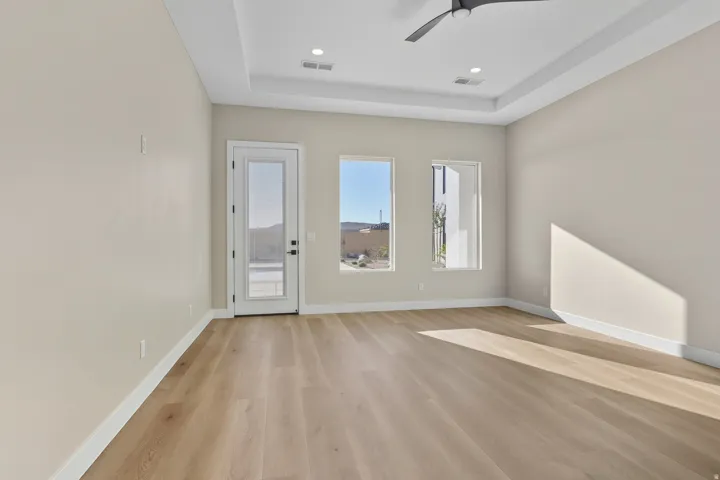 Entrance foyer featuring light wood-type flooring, ceiling fan, a tray ceiling, and recessed lighting