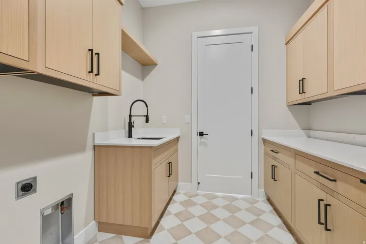 Washroom featuring light floors, cabinet space, and hookup for an electric dryer