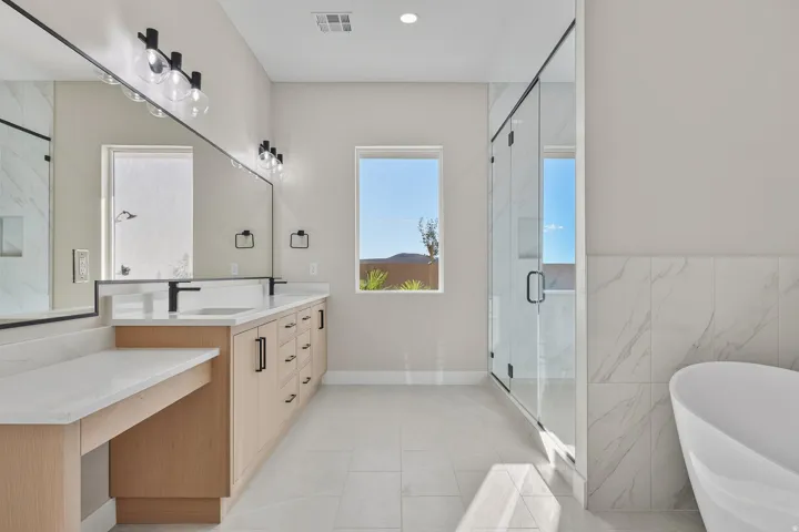 Bathroom with vanity, a freestanding tub, a stall shower, tile walls, and light tile patterned flooring