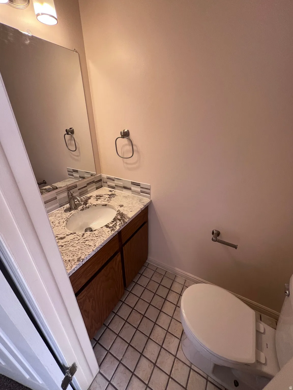 Half bath featuring vanity and light tile patterned floors