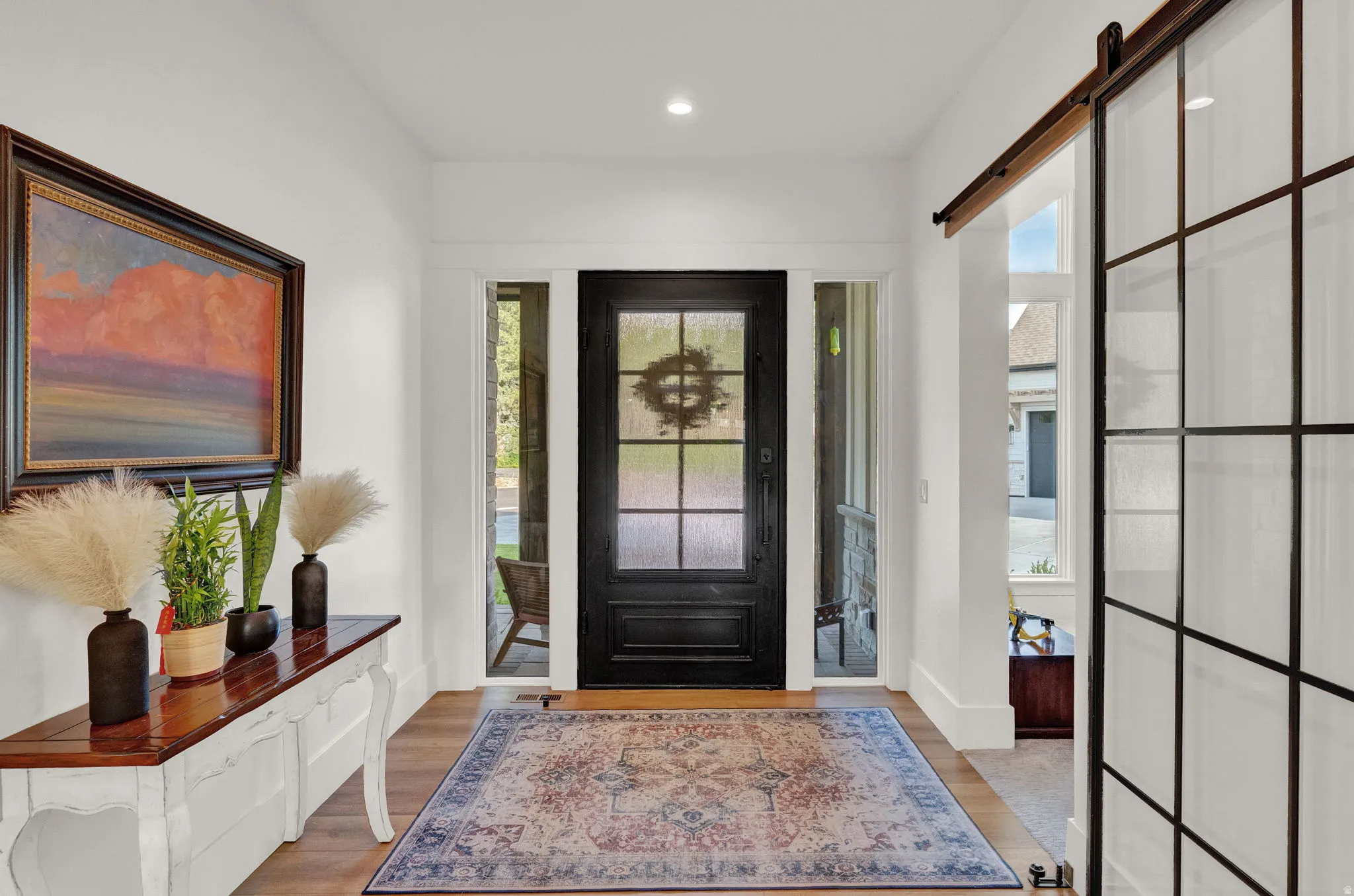 Entryway with a barn door, light wood finished floors, and recessed lighting
