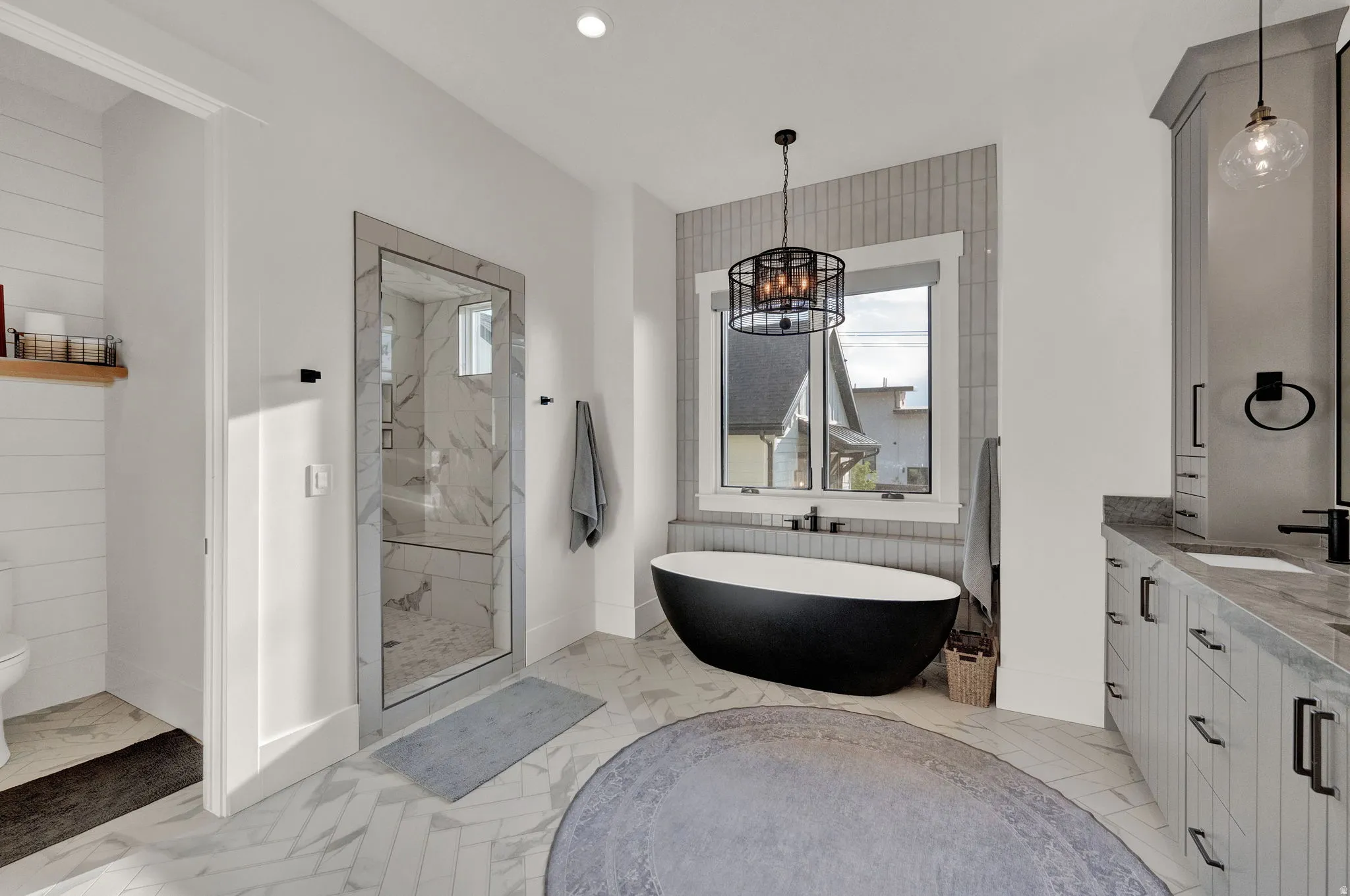 Full bath featuring a marble finish shower, plenty of natural light, a freestanding tub, vanity, and recessed lighting