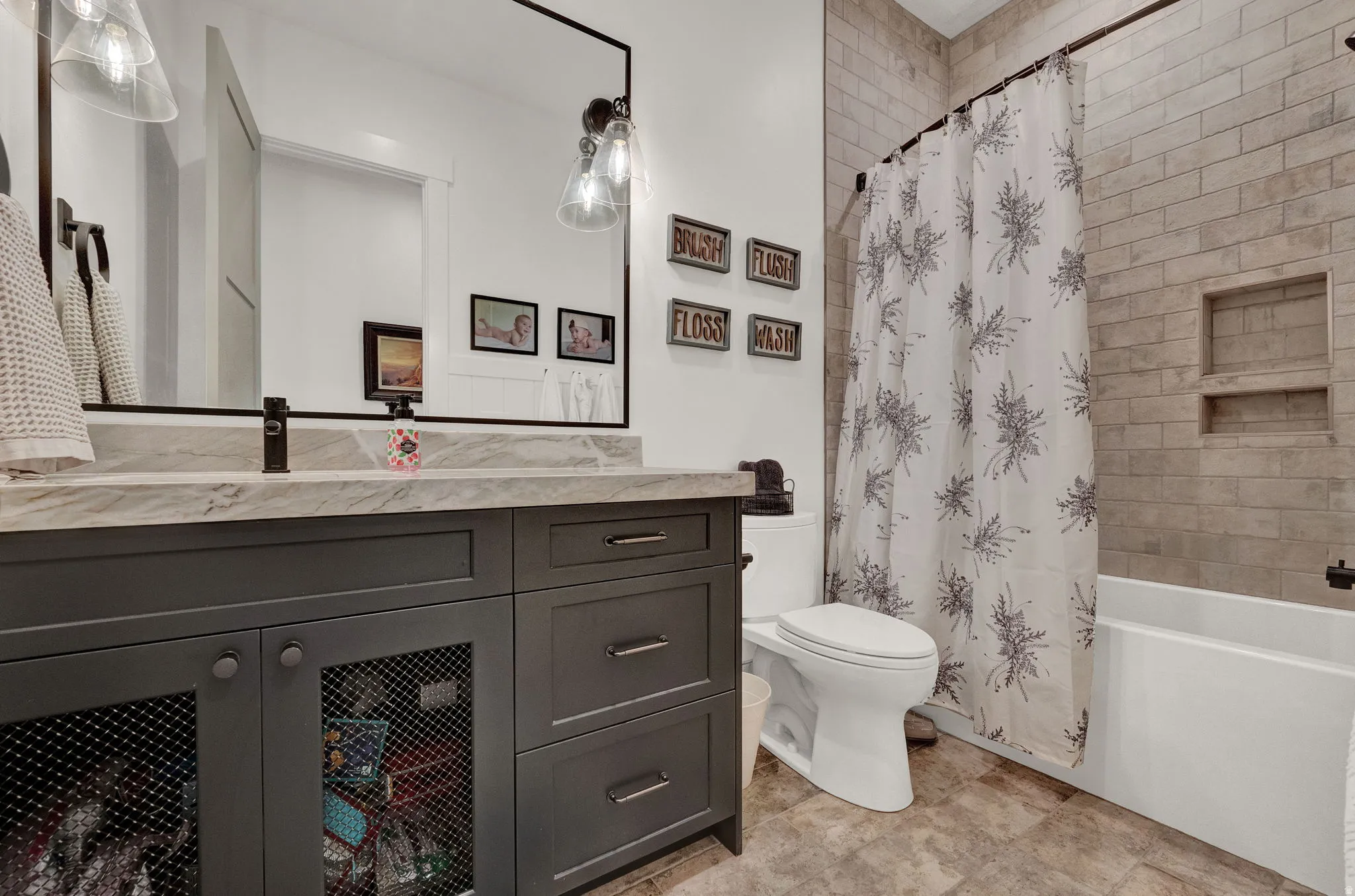 Full bath with shower / tub combo with curtain and vanity
