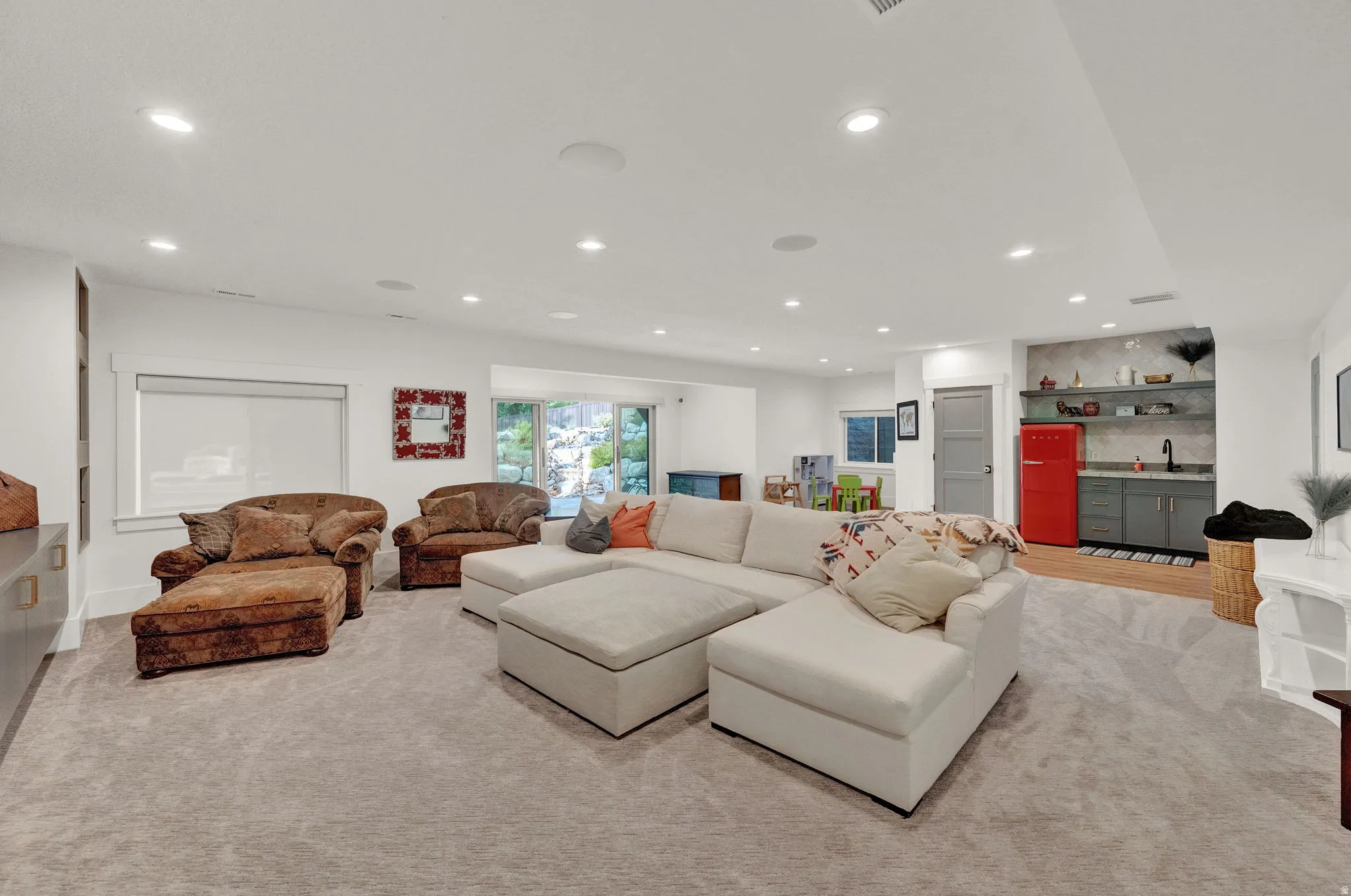 Living room with recessed lighting, wet bar, and light carpet