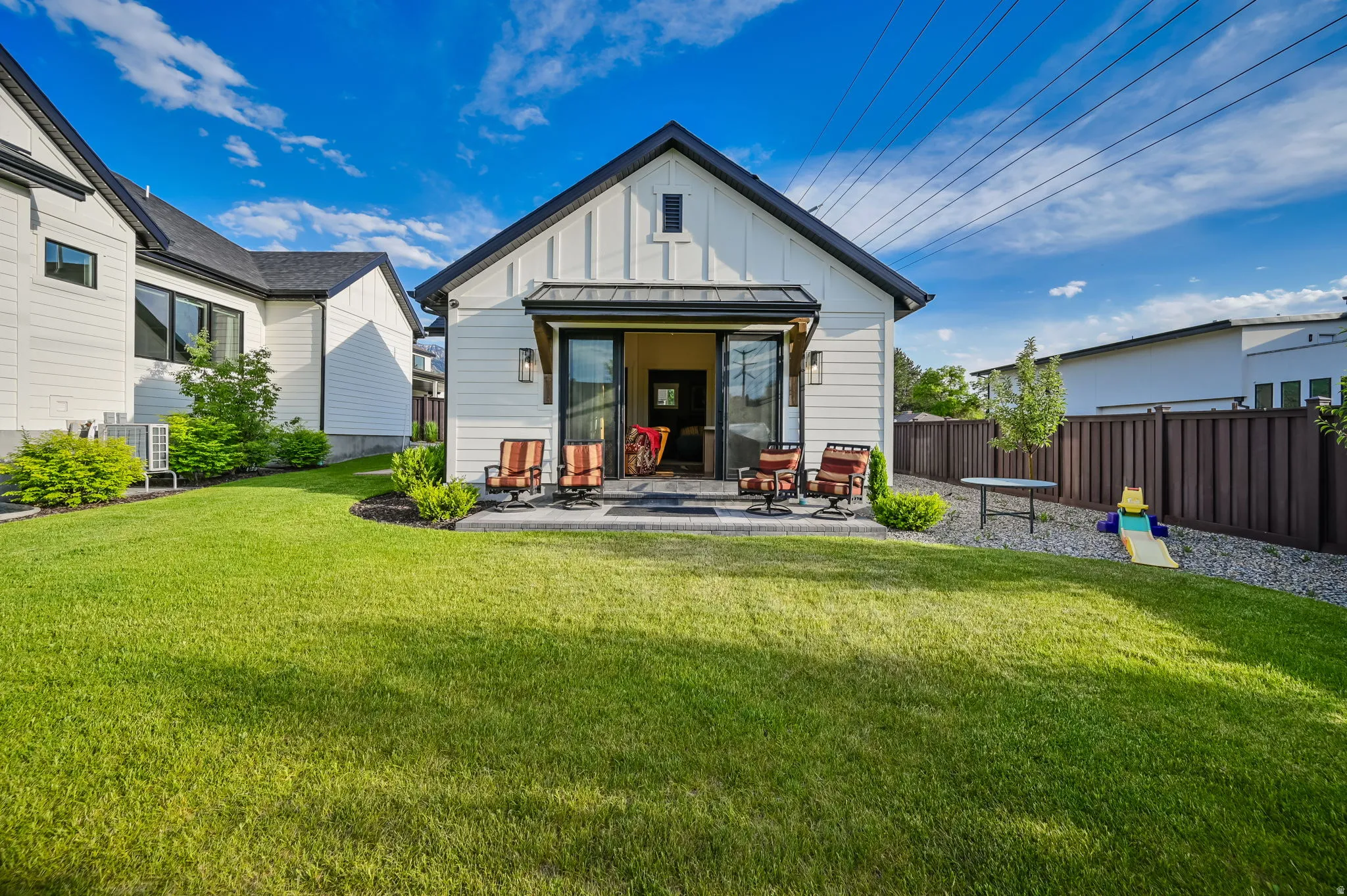 Back of house featuring board and batten siding and a patio area