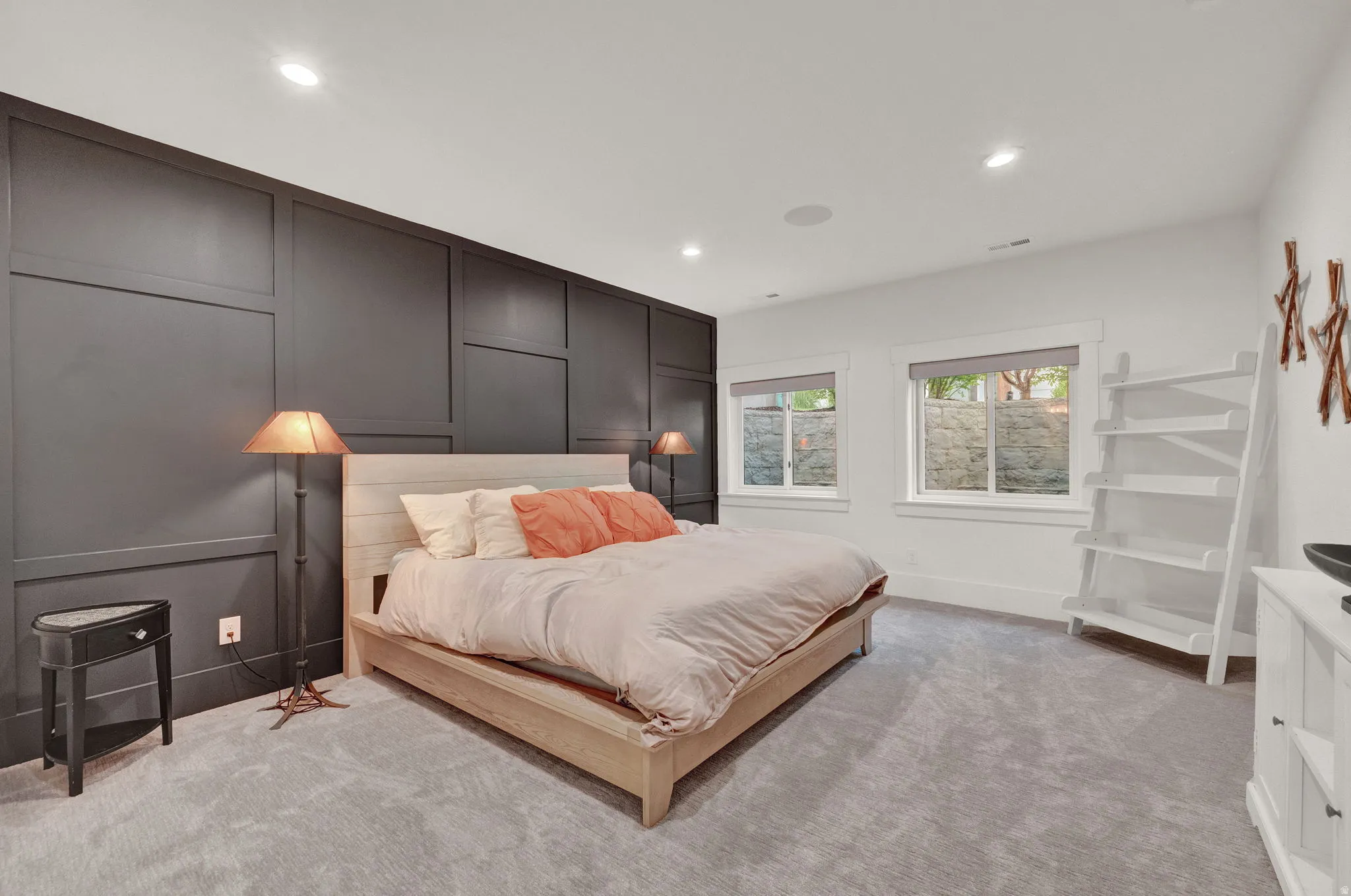 Bedroom featuring a decorative wall, recessed lighting, and light carpet