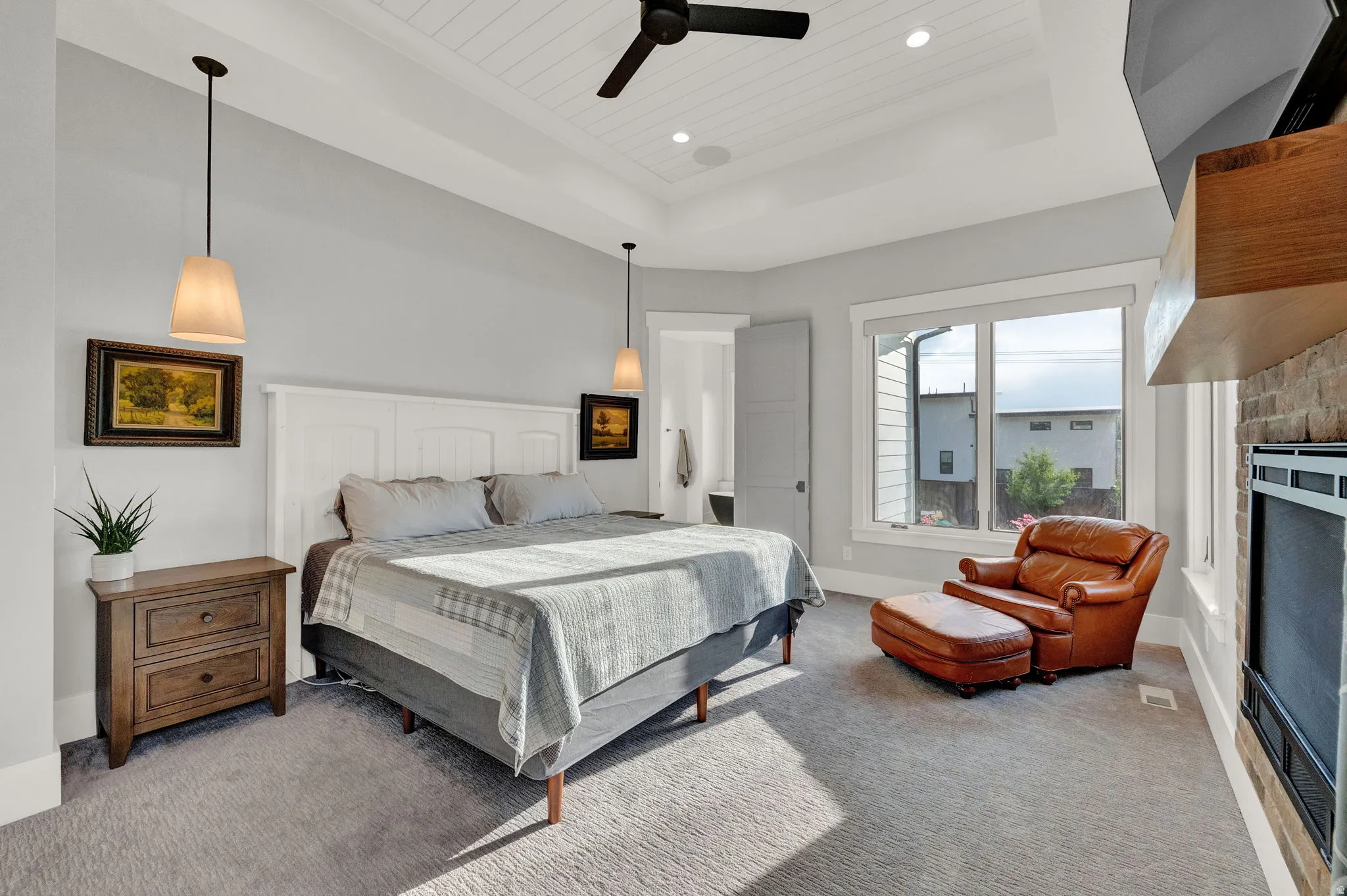 Bedroom featuring a raised ceiling, carpet floors, ceiling fan, a fireplace, and wooden ceiling