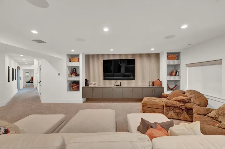 Living area with built in features, light colored carpet, and recessed lighting