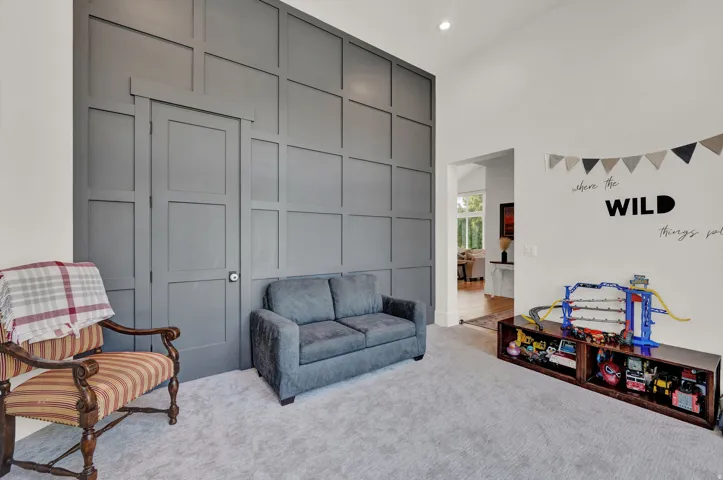 Living area featuring carpet flooring, a high ceiling, and recessed lighting