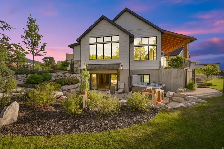 Back of house with a patio, a balcony, a standing seam roof, a metal roof, and stairs