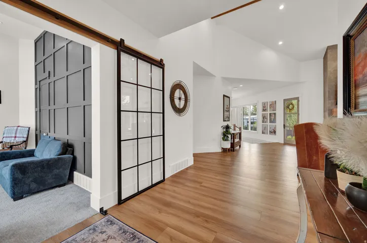 Foyer entrance featuring a barn door, wood finished floors, recessed lighting, and high vaulted ceiling