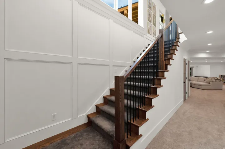 Staircase featuring recessed lighting, carpet floors, and a decorative wall