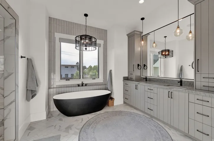 Full bathroom with a chandelier, double vanity, a freestanding bath, light marble finish floors, and recessed lighting