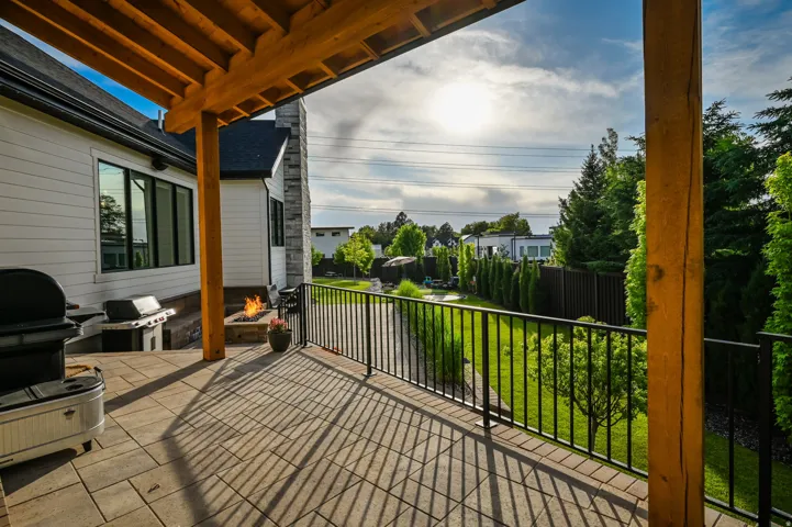 Wooden terrace featuring a grill, an outdoor fire pit, and a yard
