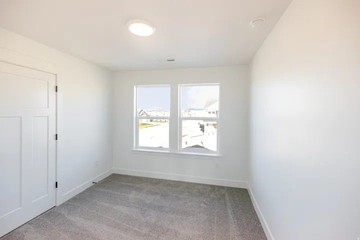 Empty room featuring light carpet and baseboards