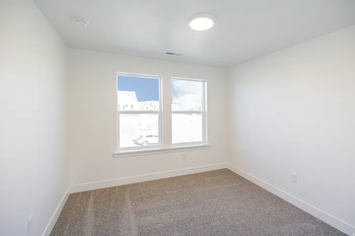Carpeted empty room with baseboards