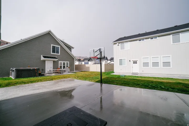 Rear view of property with a patio area and a hot tub