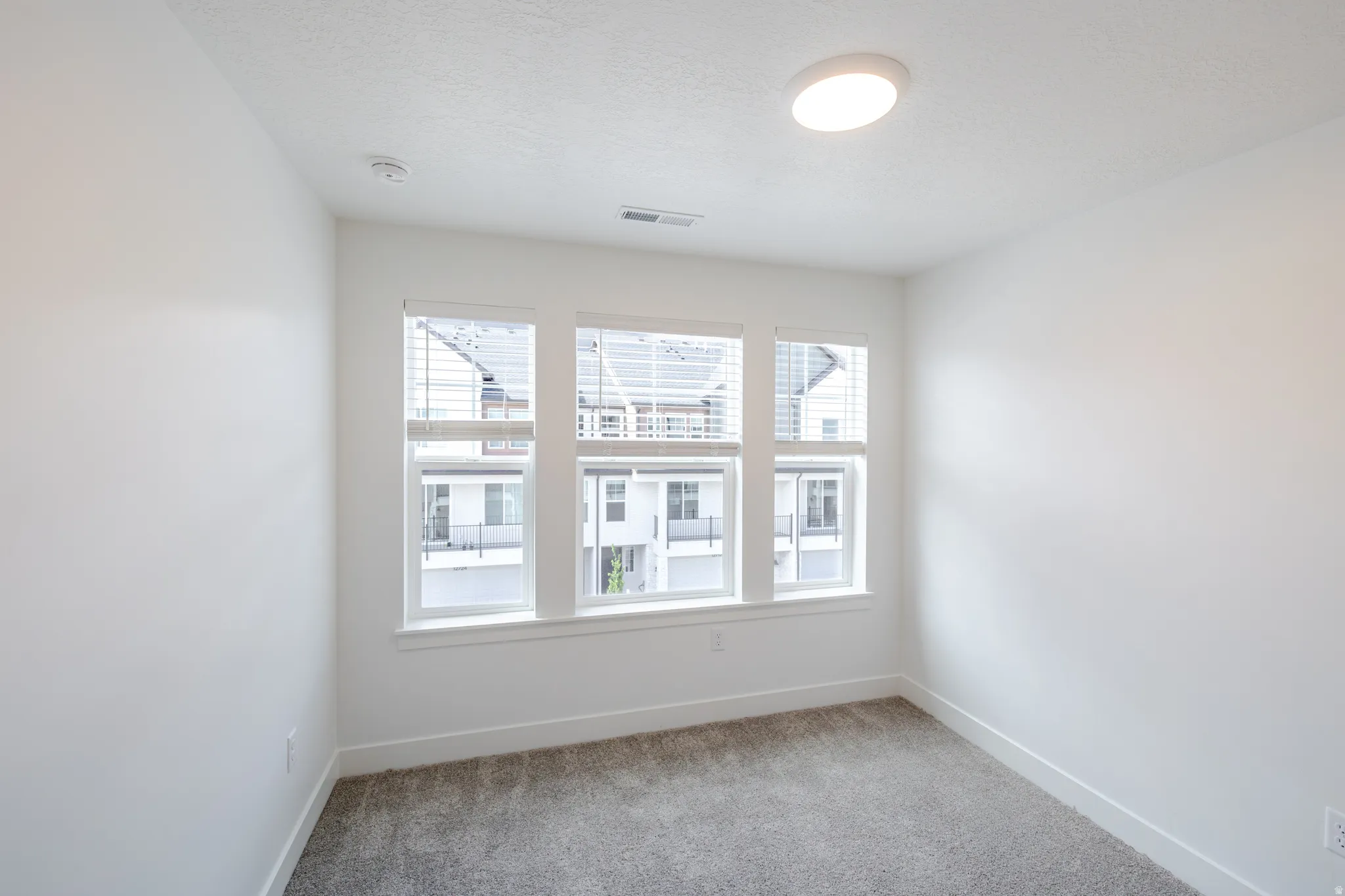 Spare room featuring light carpet and baseboards