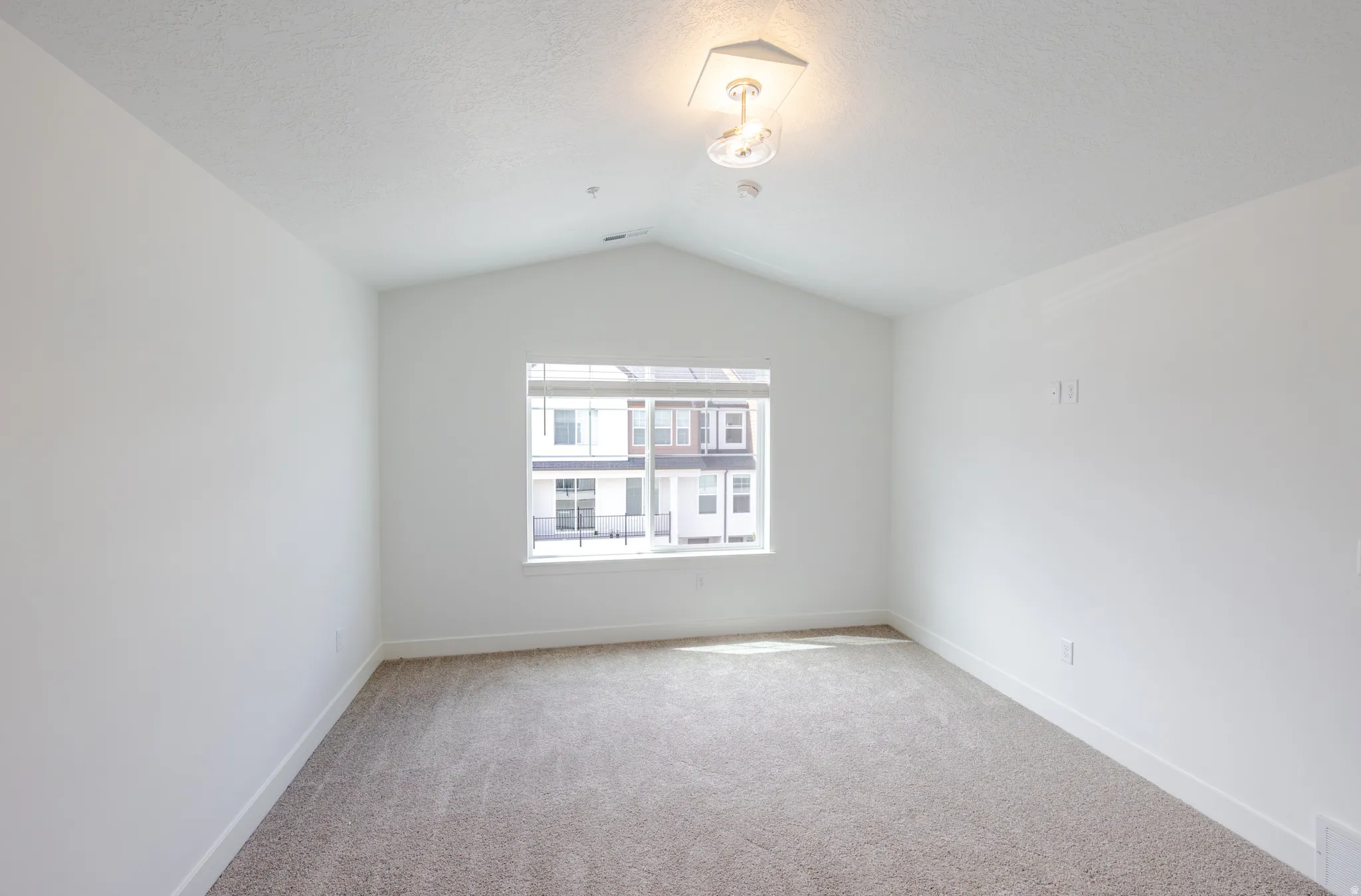 Carpeted spare room featuring baseboards and a textured ceiling