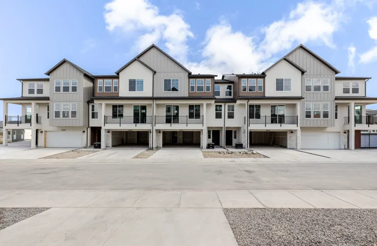 View of front of home featuring a garage, driveway, a residential view, and board and batten siding