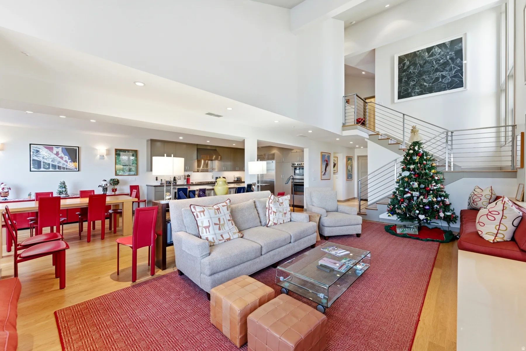 Living room with a towering ceiling, light wood-style floors, stairway, and recessed lighting