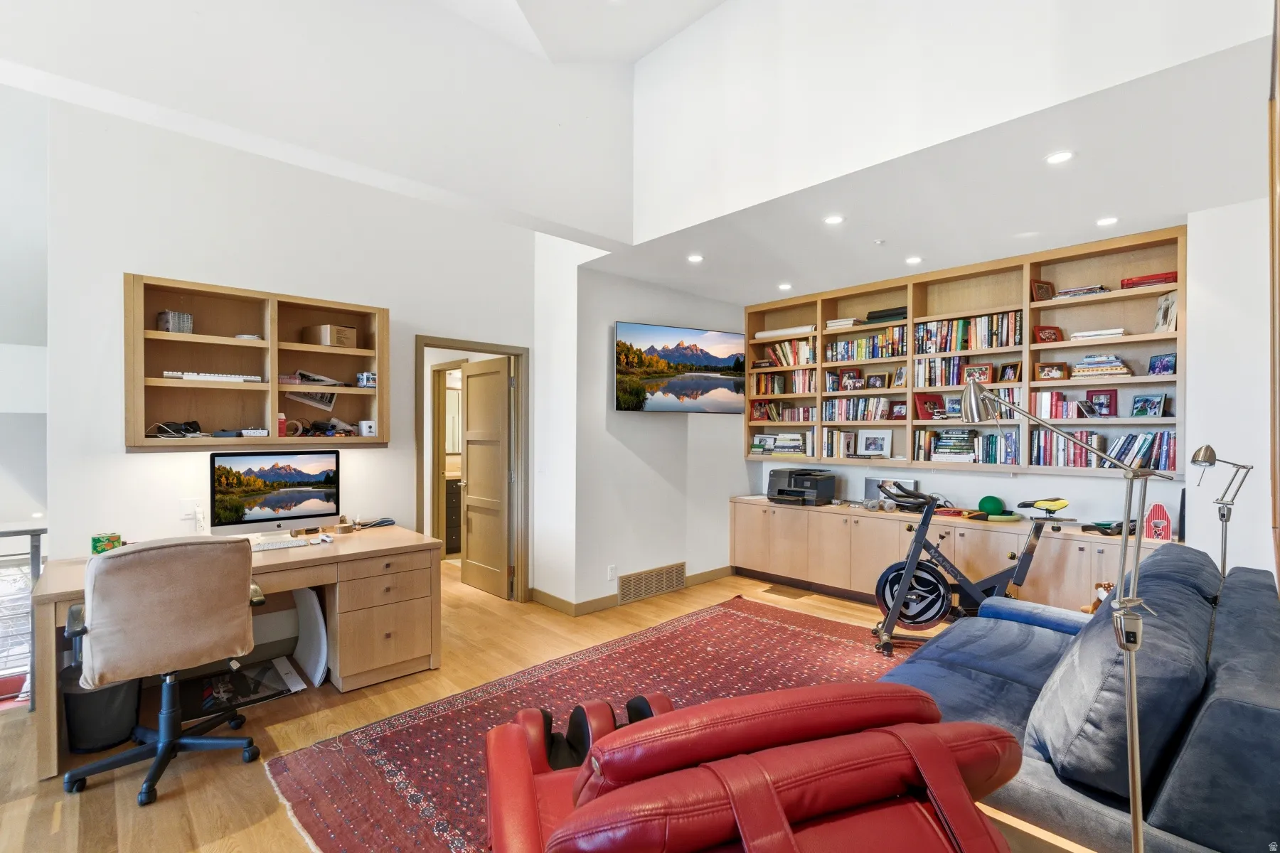 Office featuring built in study area, recessed lighting, a high ceiling, light wood-type flooring, and built in shelves