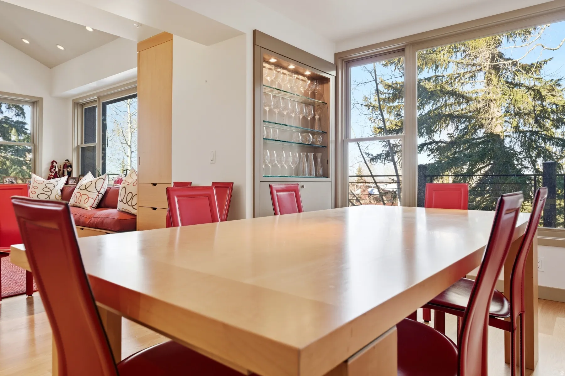 Dining room with light wood finished floors, a bar, and lofted ceiling