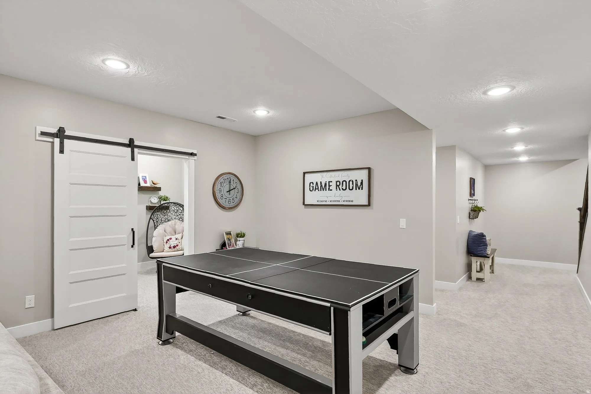 Game room with a barn door, light colored carpet, and recessed lighting