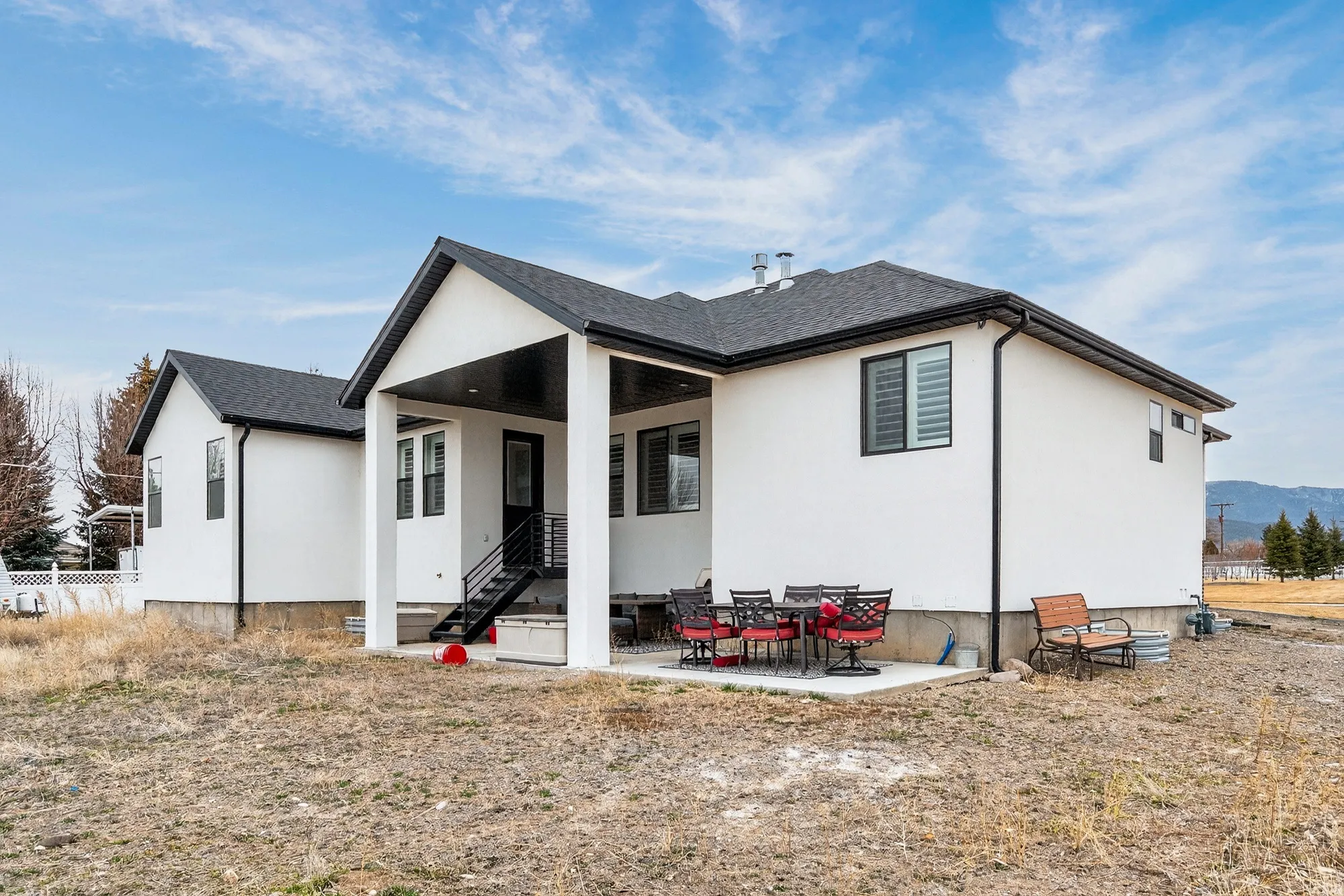 Back of house with a patio area, stucco siding, a shingled roof, and outdoor dining area