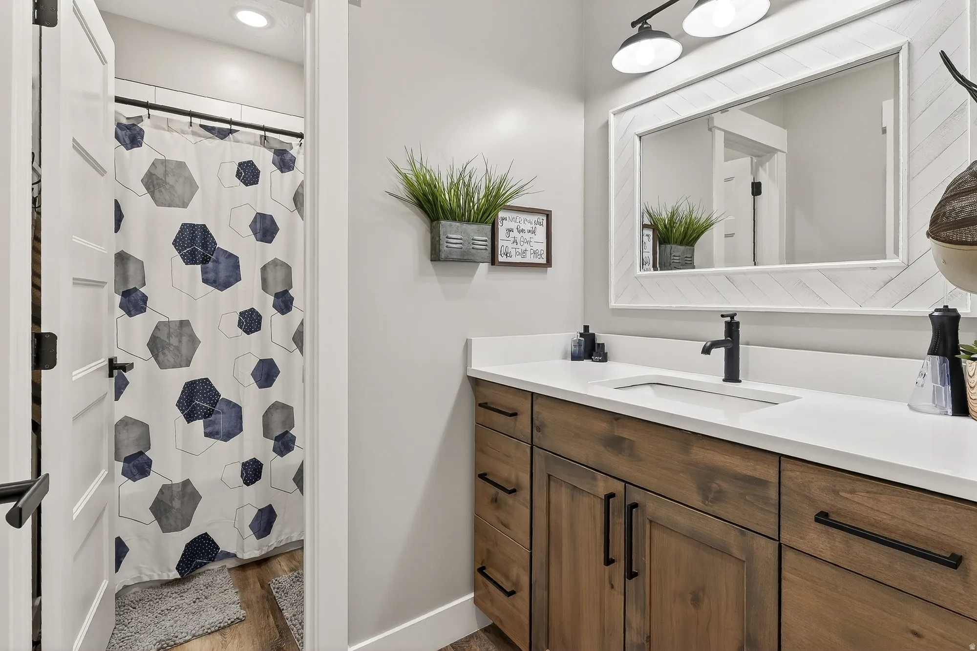 Full bathroom featuring vanity, a shower with shower curtain, and light wood finished floors