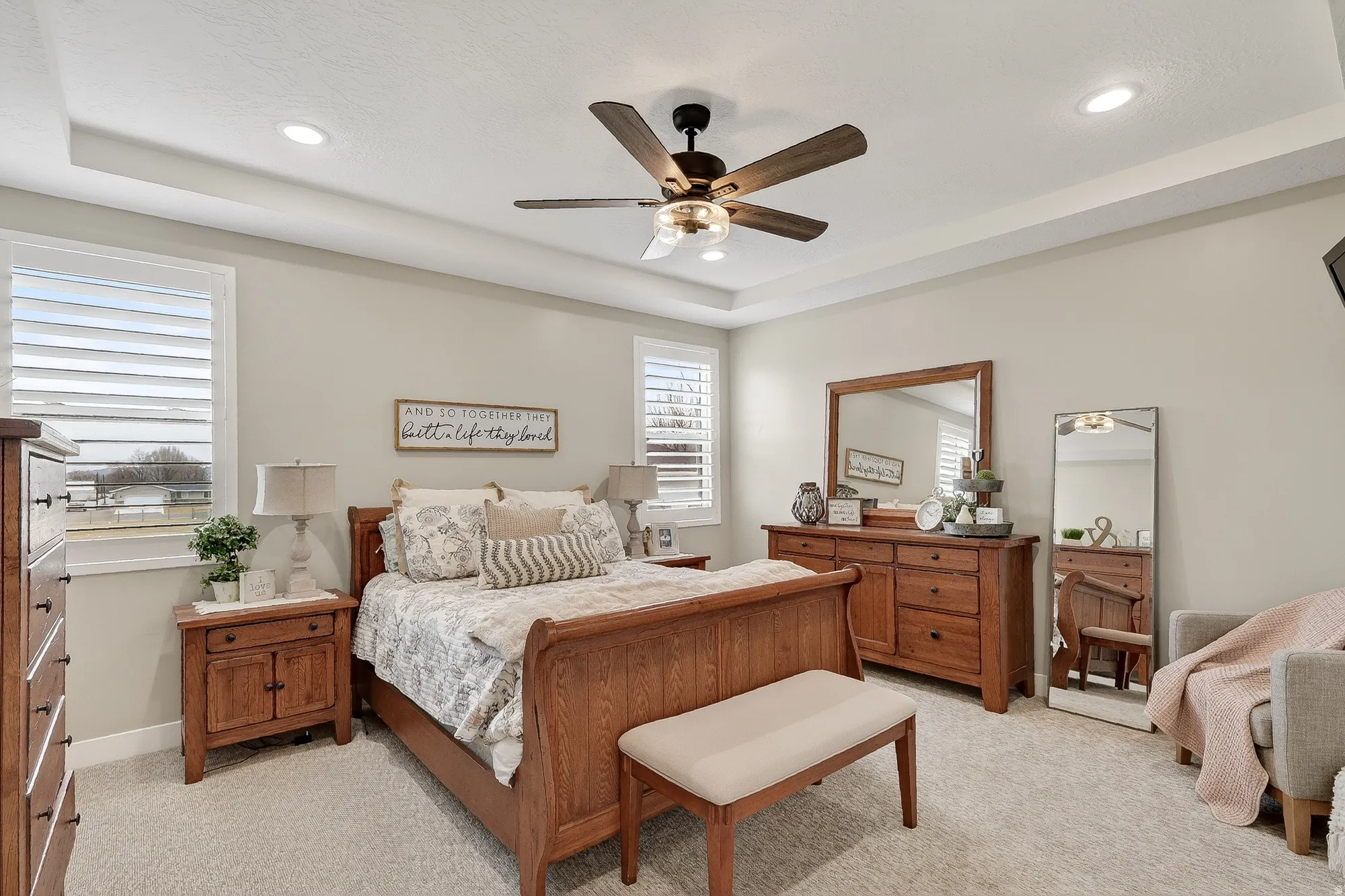 Bedroom featuring ceiling fan, light carpet, a tray ceiling, and recessed lighting