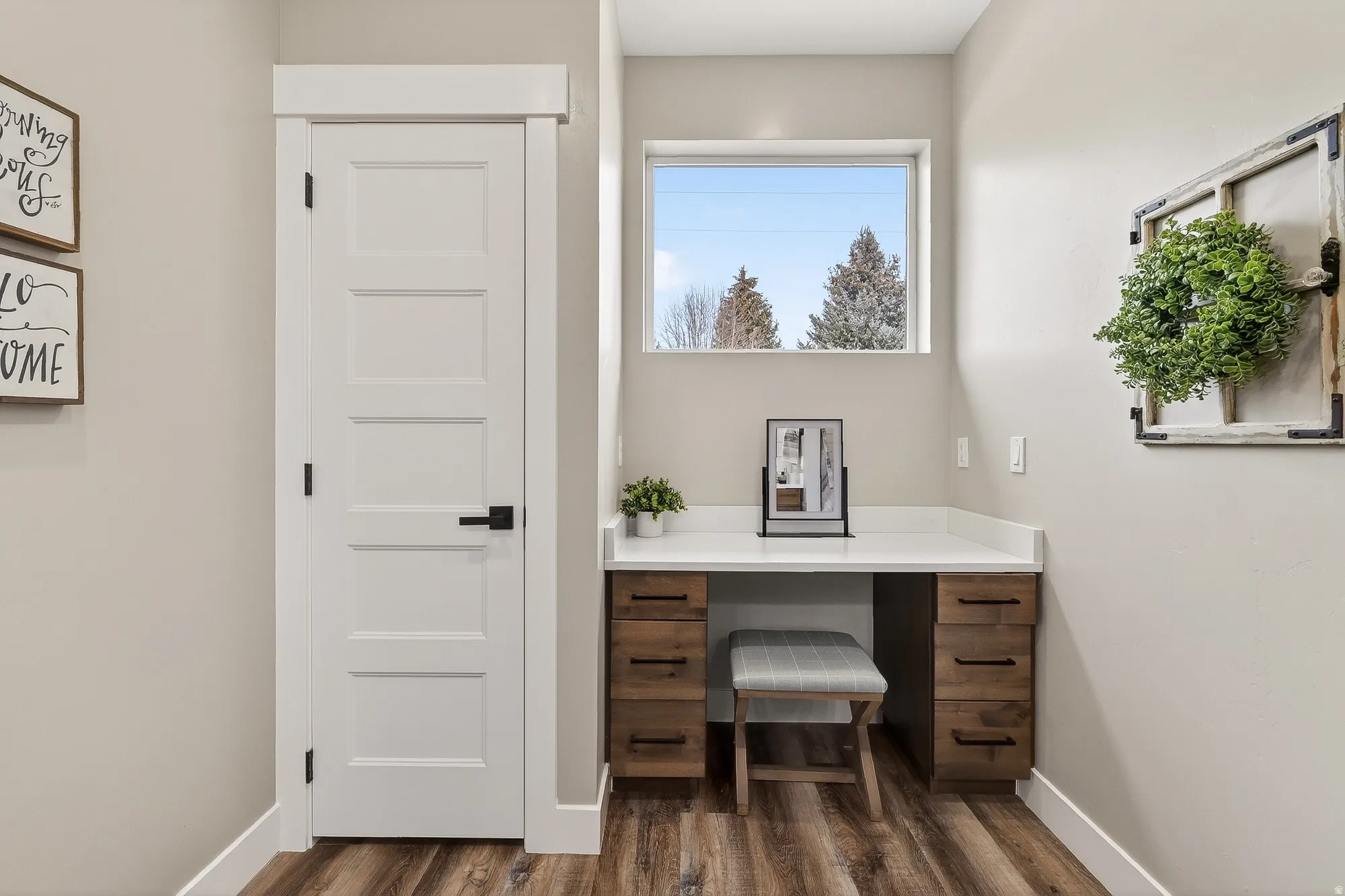 Office with built in desk and dark wood finished floors
