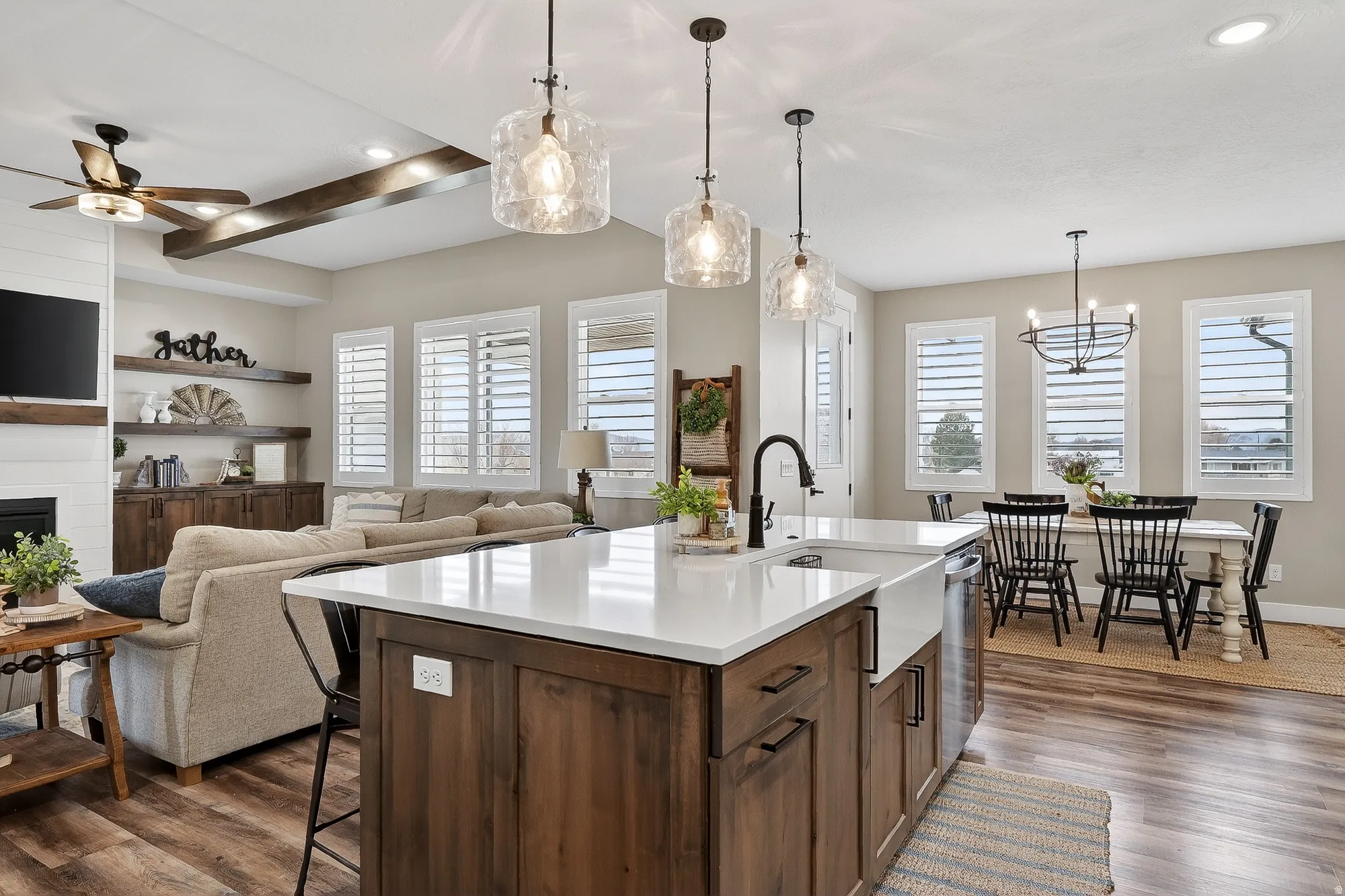 Kitchen featuring a kitchen breakfast bar, dark wood-style floors, an island with sink, open floor plan, and ceiling fan