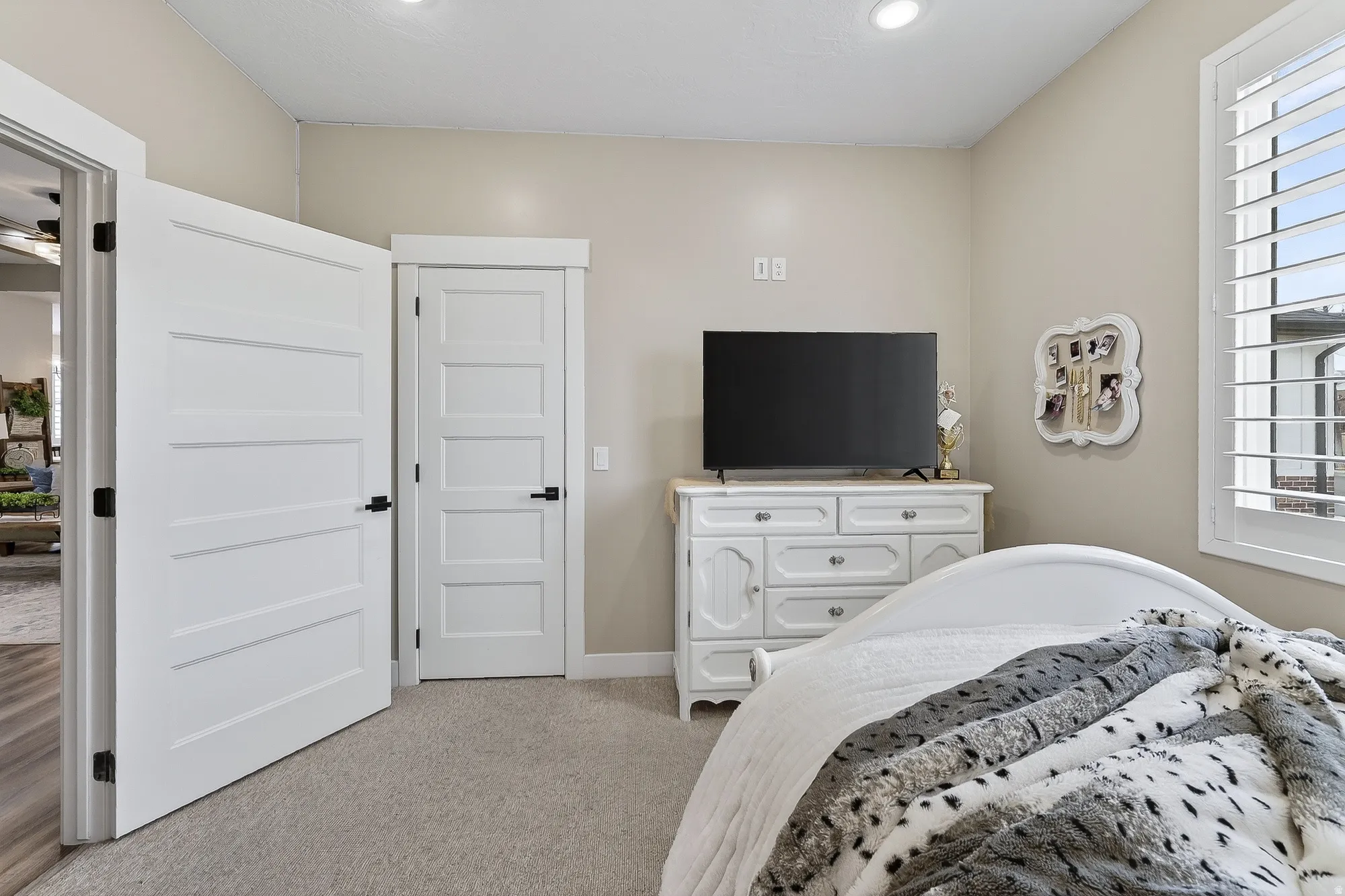 Bedroom with light colored carpet and baseboards